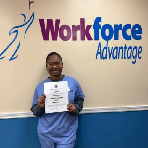 Carina Normil holding her CNA training certificate at Urban WorkForce Advantage